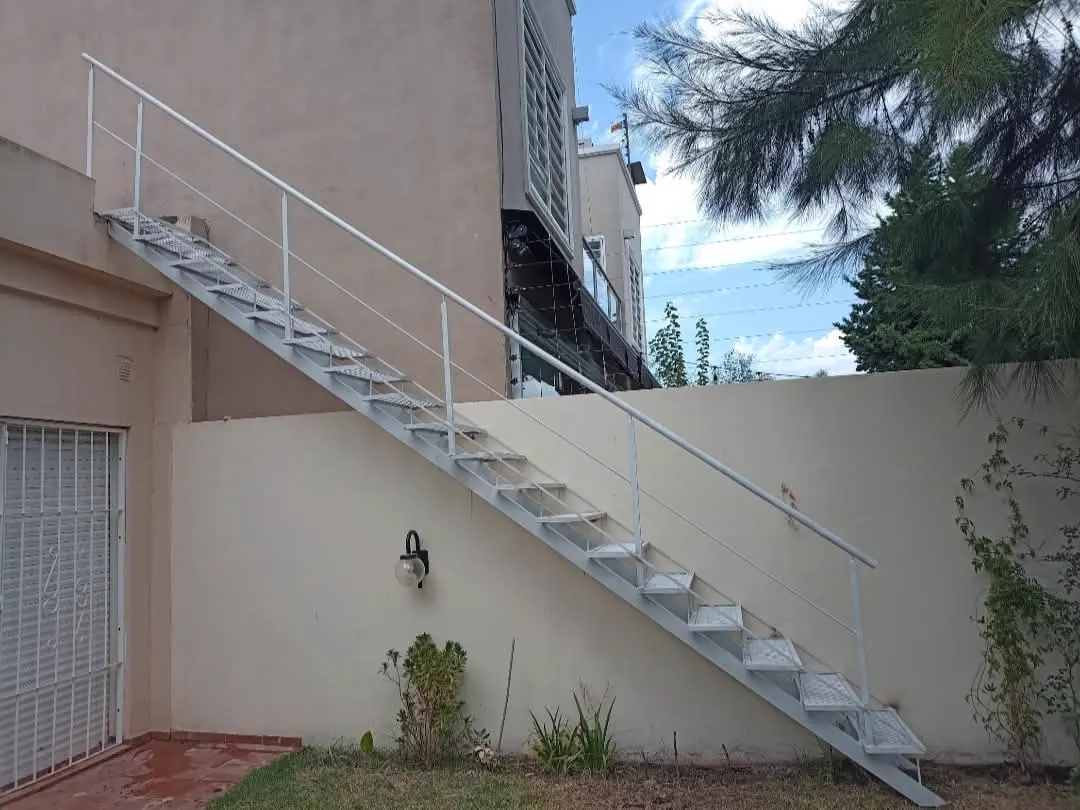 Escalera metálica exterior blanca con baranda